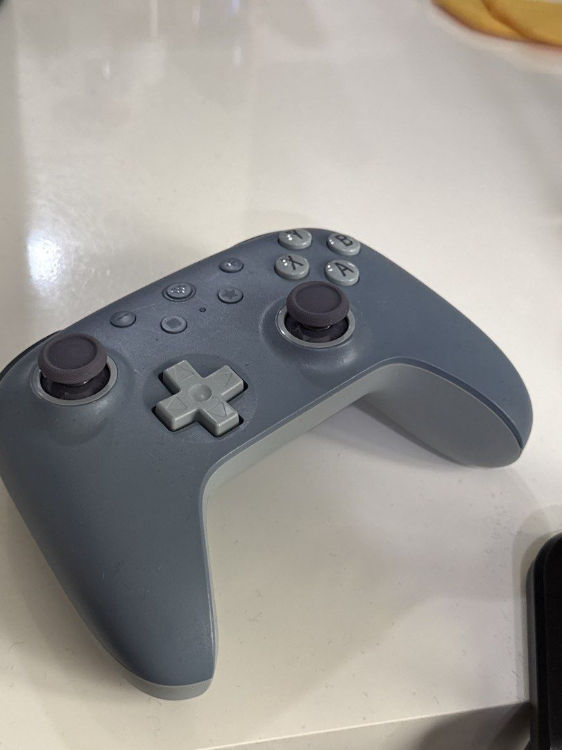 8BitDo Ultimate 2C Wireless Controller Grey (Category: Controllers) located in Kuala Lumpur. Submitted by komi2311 (Listing ID 1469218190, Image 1). Description: - Model: 8BitDo Ultimate 2C Wireless Controller - Color: Grey body with dark grey thumbsticks and D-pad - Connectivity: Bluetooth and 2.4G support - Layout: Standard face button configuration.
