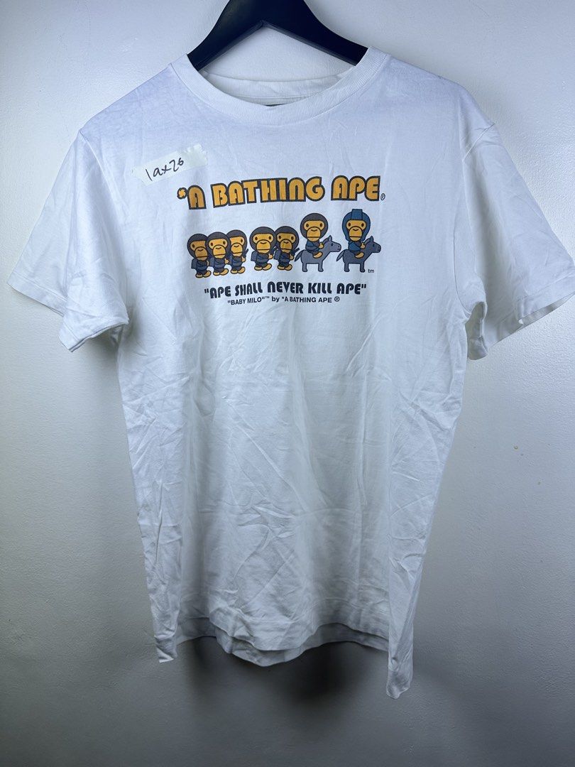 A Bathing Ape Baby Milo Ape Shall Never Kill Ape Tee (Category: Tshirts & Polo Shirts ) located in Manila. Submitted by declutterpromax (Listing ID 1469222173, Image 1). Description: - Color: Clean white with iconic front graphic - Design: Classic 'Ape Shall Never Kill Ape' print - Details: Signature Bape sleeve tag on left cuff and gray size neck tag - Fit: Short sleeves with a comfortable round collar.