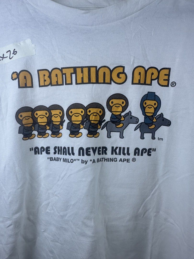 A Bathing Ape Baby Milo Ape Shall Never Kill Ape Tee (Category: Tshirts & Polo Shirts ) located in Manila. Submitted by declutterpromax (Listing ID 1469222173, Image 3). Description: - Color: Clean white with iconic front graphic - Design: Classic 'Ape Shall Never Kill Ape' print - Details: Signature Bape sleeve tag on left cuff and gray size neck tag - Fit: Short sleeves with a comfortable round collar.
