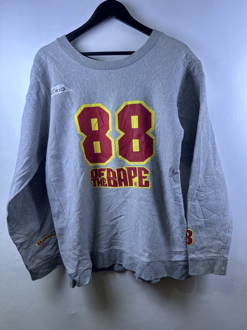 A Bathing Ape BAPE 88 Grey Sweatshirt (Category: Coats, Jackets and Outerwear) located in Manila. Submitted by declutterpromax (Listing ID 1469223229, Image 1). Description: - Brand: A Bathing Ape (BAPE) - Color: Grey - Material: Comfortable cotton fleece - Fit: Regular fit with ribbed cuffs and hem - Design: Eye-catching red and yellow '88' BAPE chest graphic - Details: Sleeve branding and secondary logo patch near the cuff - Sizing: Taped measu