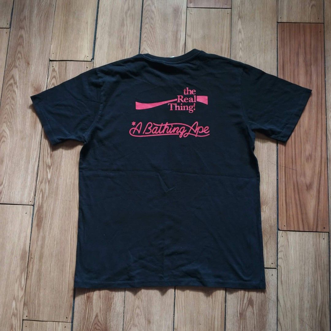 A Bathing Ape x Coca Cola MMXX Tee Size XL (Category: Tshirts & Polo Shirts ) located in Paranaque City. Submitted by thriftine5 (Listing ID 1469165377, Image 2). Description: - Brand: BAPE x Coca-Cola Collaboration - Color: Black - Size: XL - Condition: Clean fabric, no flaws spotted, includes regular collar and sleeve tags - Front Design: Iconic ape head filled with red stars over classic script logo, plus a woven jock tag near the hem - Back D