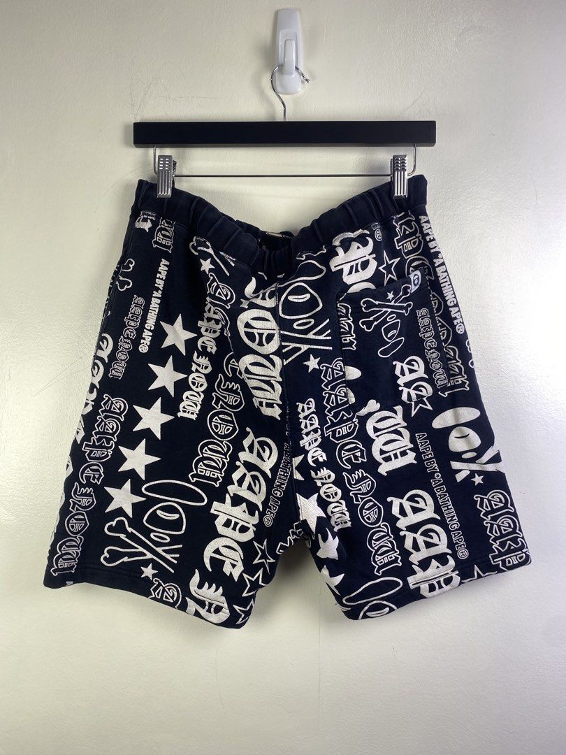 Aape by A Bathing Ape All Over Print Shorts (Category: Shorts) located in Manila. Submitted by declutterpromax (Listing ID 1469201984, Image 3). Description: - Brand: Aape by A Bathing Ape - Color: Black with bold white all-over graphic print (lettering & stars) - Waistband: Elastic with signature Aape velcro patch - Material: 74.1% cotton blend (Made in China) - Size: Tag reads 175/82A (marked 32x19x10) - Condition: Excellent streetwear conditio