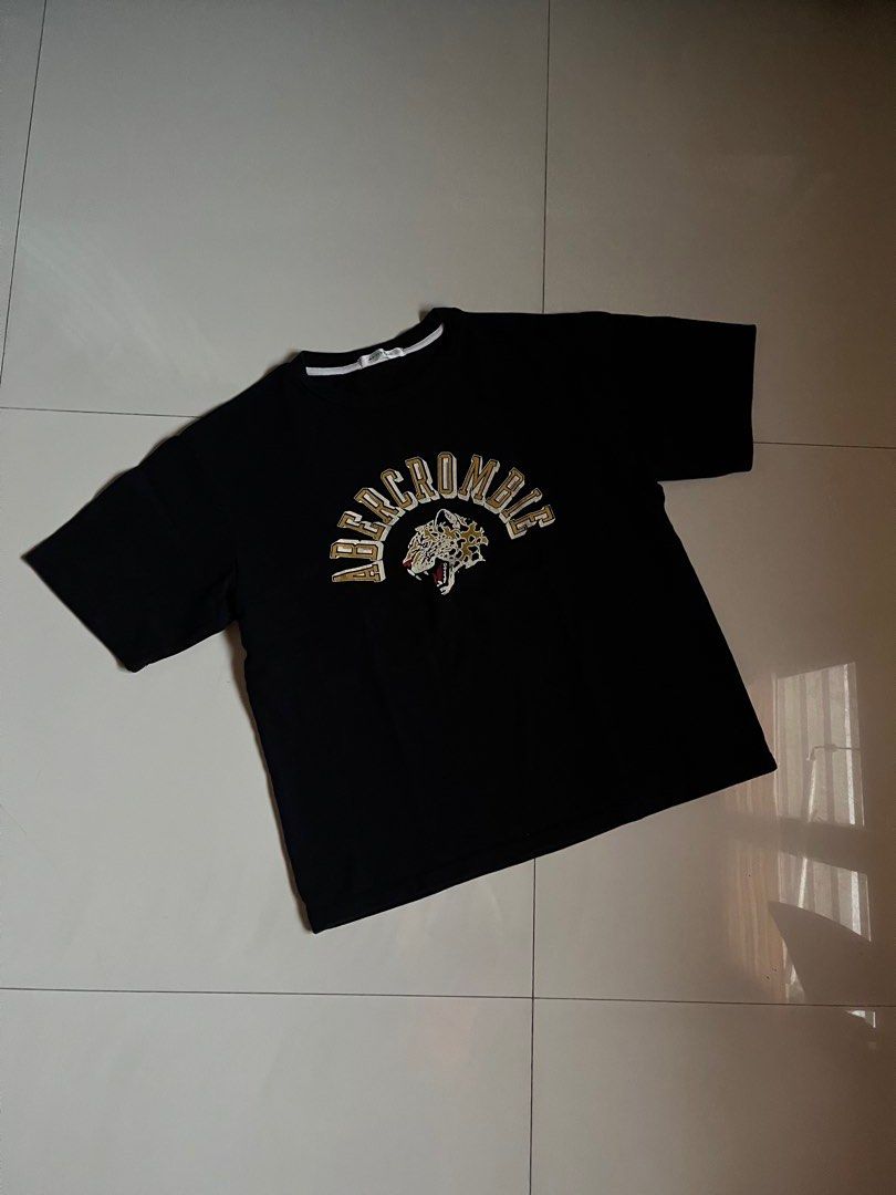 Abercrombie Black Graphic T-shirt (Category: Tshirts & Polo Shirts ) located in Manila. Submitted by newbird.d02ae2 (Listing ID 1469246736, Image 1). Description: Color: Black with gold and white chest graphic Fit: Large, Standard relaxed fit Details: Crew neck with contrast white inner trim tape Condition: Excellent pre-loved / like new Mode of Payment: GCash .