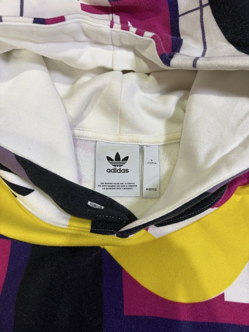 Adidas Catalog AOP Hoodie Multicolor Size S (Category: Hoodies) located in Manila. Submitted by _valuevault777 (Listing ID 1469178141, Image 3). Description: - Brand: Adidas - Model: Catalog AOP Hoodie - Size: S - Design: Multi-colored abstract graphic print with white base, black, purple, yellow, magenta, and integrated Trefoil logos - Features: Kangaroo front pocket, adjustable drawstring hood, ribbed cuffs and hem - Material: 77% cotton, 23% r