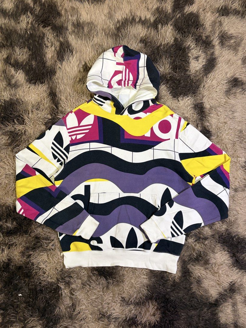 Adidas Catalog AOP Hoodie Multicolor Size S (Category: Hoodies) located in Manila. Submitted by _valuevault777 (Listing ID 1469178141, Image 1). Description: - Brand: Adidas - Model: Catalog AOP Hoodie - Size: S - Design: Multi-colored abstract graphic print with white base, black, purple, yellow, magenta, and integrated Trefoil logos - Features: Kangaroo front pocket, adjustable drawstring hood, ribbed cuffs and hem - Material: 77% cotton, 23% r
