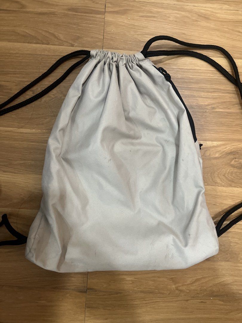 Adidas Drawstring Bag Off White Gym Sack (Category: Backpacks) located in San Fernando. Submitted by nathan_pasahol (Listing ID 1469254325, Image 2). Description: - Brand: Adidas - Color: Off-white with black cord straps - Features: Front zip pocket with circular Adidas logo patch & diamond-shaped lash tab accent - Condition: Clean interior, sturdy rope drawstrings, with faint dirt smudges near the bottom backside - Perfect for daily use, gym, or