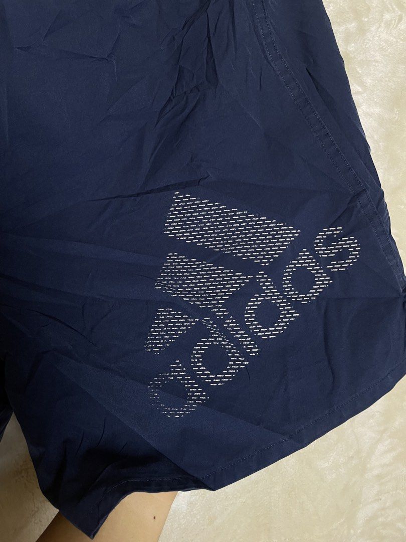 Adidas Navy Blue Athletic Shorts (Category: Shorts) located in Molave. Submitted by charlesthrifter (Listing ID 1469203050, Image 2). Description: - Brand: Adidas - Color: Navy blue - Material: Lightweight and breathable, perfect for workouts or casual wear - Waistband: Elastic with adjustable inner drawstring - Design: Large textured Adidas branding graphic on the lower left leg.