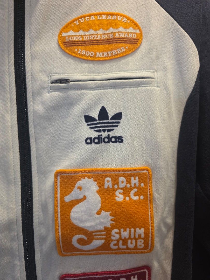Adidas Track Jacket Multi-Patch Zip Up (Category: Coats, Jackets and Outerwear) located in Santiago. Submitted by epicstar.7cb176 (Listing ID 1469166851, Image 2). Description: Adidas Originals Retro Swimming Club Track Jacket - Color: Navy blue and white - Style: Track jacket with full zip front and classic three stripes on sleeves - Details: Unique embroidered swim club and award patches on chest and front panel - Pockets: Convenient zippered p