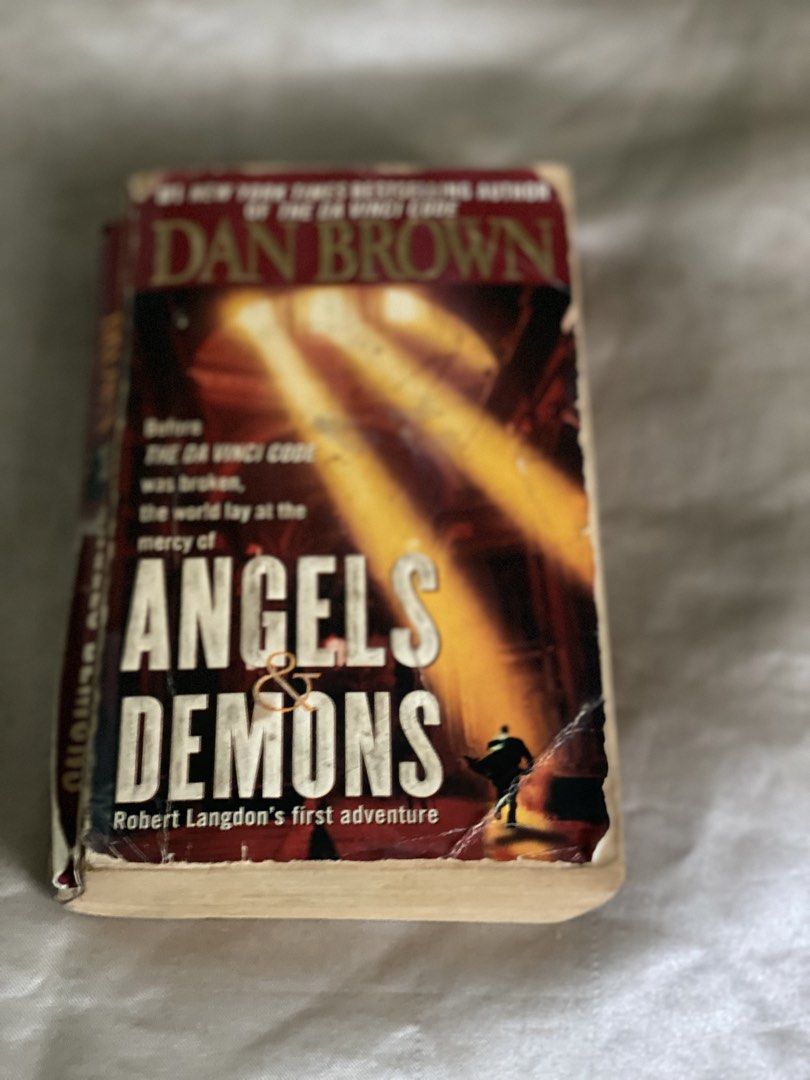 Angels & Demons by Dan Brown paperback novel (Category: Storybooks) located in Manila. Submitted by geminibibo (Listing ID 1469225924, Image 1). Description: - Title: Angels & Demons by Dan Brown - Series: Robert Langdon #1 - Format: Paperback - Condition: Heavy wear on cover (creasing and peeling corners), but all pages are intact and readable - Note: Great budget copy for readers - Reason for selling: Clearing out bookshelf.