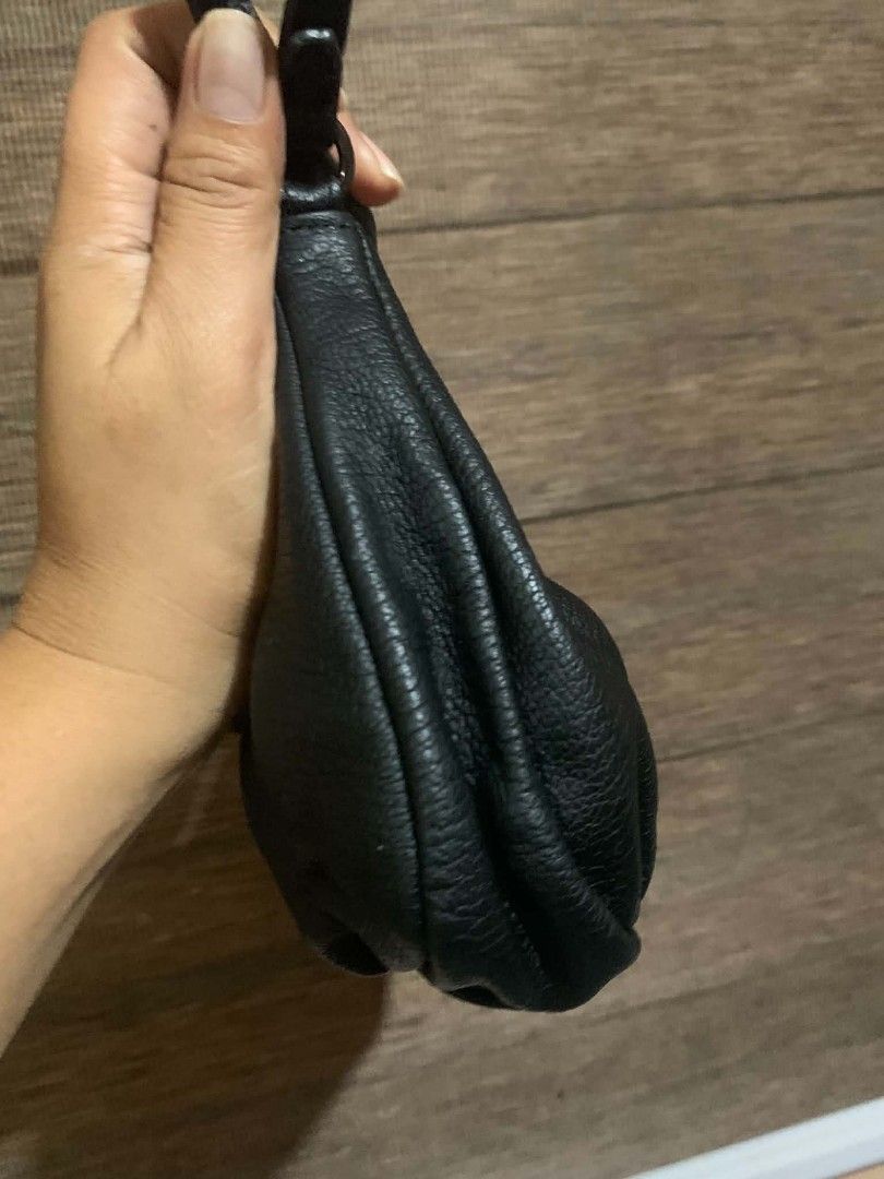 Anne Klein Black Leather Shoulder Bag (Category: Shoulder Bags) located in Aliaga. Submitted by akishaoshop2010. (Listing ID 1469175159, Image 3). Description: - Brand: Anne Klein - Material: Soft black pebble leather - Style: Slouchy hobo shoulder bag with single strap drop - Closure: Zip top with double leather pull tabs - Details: Subtle embossed AK logo near the top edge - Size: Compact and spacious enough for daily essentials - Condition: Ex