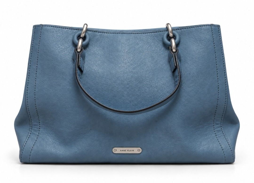 Anne Klein Blue Tote Handbag (Category: Tote Bags) located in Quezon City. Submitted by gorgeousvixen051893 (Listing ID 1469340147, Image 1). Description: - Brand: Anne Klein - Material: Premium blue faux leather - Hardware: Chic silver-tone rings and front metal brand plaque - Design: Dual handles, vertical double-stitch front details, and a structured base - Interior: Clean and spacious main compartment - Condition: Excellent, well-maintained.