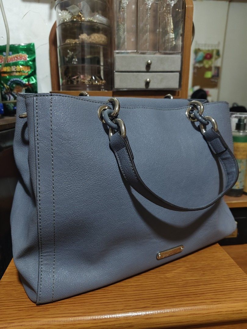 Anne Klein Blue Tote Handbag (Category: Tote Bags) located in Quezon City. Submitted by gorgeousvixen051893 (Listing ID 1469340147, Image 3). Description: - Brand: Anne Klein - Material: Premium blue faux leather - Hardware: Chic silver-tone rings and front metal brand plaque - Design: Dual handles, vertical double-stitch front details, and a structured base - Interior: Clean and spacious main compartment - Condition: Excellent, well-maintained.