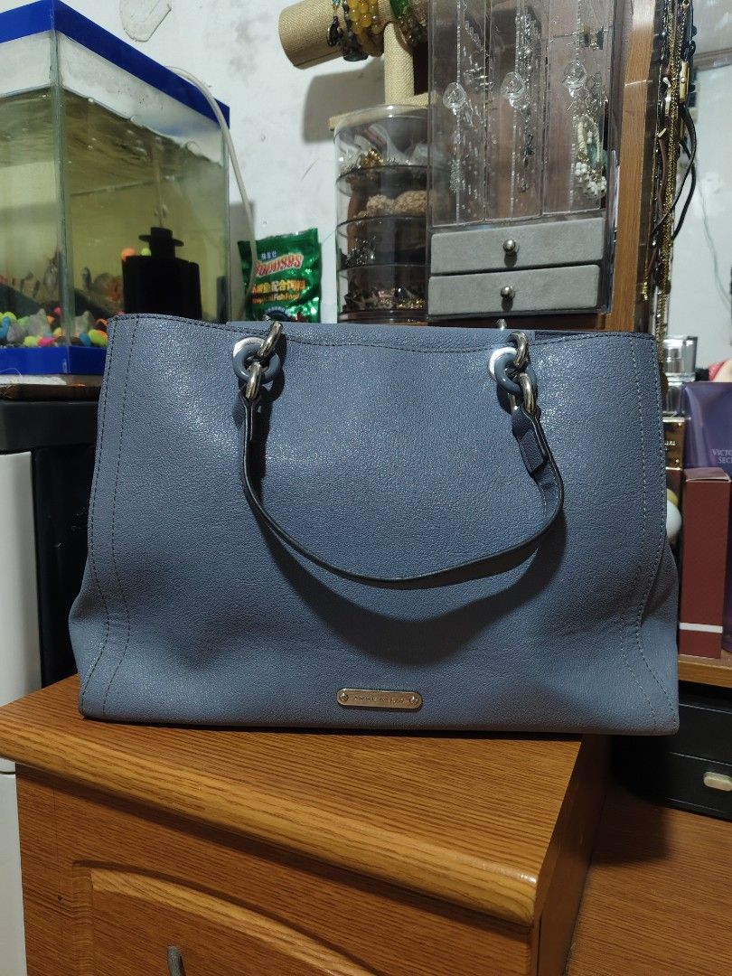 Anne Klein Blue Tote Handbag (Category: Tote Bags) located in Quezon City. Submitted by gorgeousvixen051893 (Listing ID 1469340147, Image 2). Description: - Brand: Anne Klein - Material: Premium blue faux leather - Hardware: Chic silver-tone rings and front metal brand plaque - Design: Dual handles, vertical double-stitch front details, and a structured base - Interior: Clean and spacious main compartment - Condition: Excellent, well-maintained.