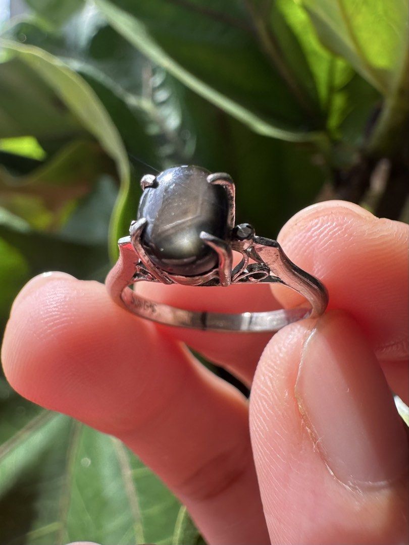 Antique Black Star Sapphire Ring Size 6 (Category: Rings) located in Mandaluyong City. Submitted by chyckenwings (Listing ID 1469181064, Image 3). Description: Preloved antique-style, high cathedral setting ring featuring an oval cabochon-cut dark stone. Stone is consistent with natural black star sapphire or a star diopside with rocky stone formation at the back. Ring is set in a silver-toned metal band with markings SING'S. Band seemed to be re