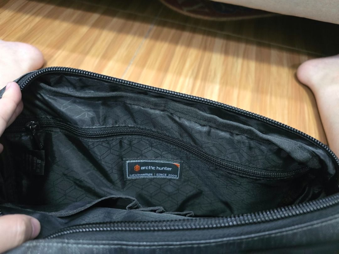 Arctic Hunter Black Messenger Crossbody Bag (Category: Sling Bags) located in Caloocan City. Submitted by elcian (Listing ID 1469276051, Image 3). Description: Arctic Hunter K00089 Shoulder Bag - Material: Water-resistant Oxford nylon cloth with water-resistant zipper - Color: Black or dark grey textured fabric - Dimensions: 34 × 9 × 24 cm - Weight: 0.55 kg - Design: Casual style with flap closure, snap buttons, and secure zippered front pocket -