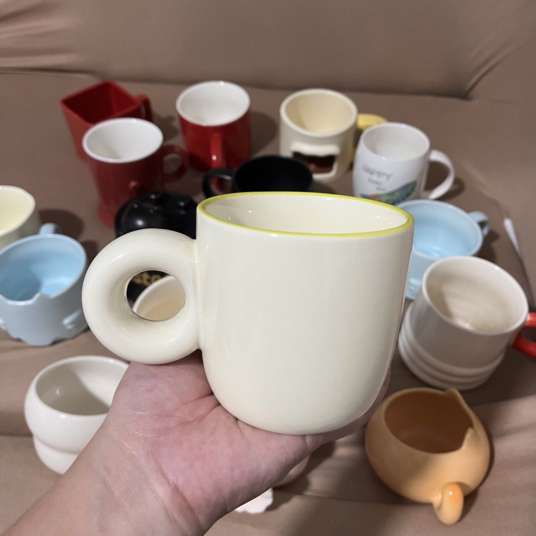 Assorted Ceramic Mugs Various Colors and Designs (Category: Coffee & Tea Tableware) located in Caloocan City. Submitted by iamqwertyy (Listing ID 1469247761, Image 3). Description: - Material: Solid, ceramic mugs - Designs: Various styles, shapes, and unique handles (round rings, raised bumps) - Perfect for daily coffee or tea.