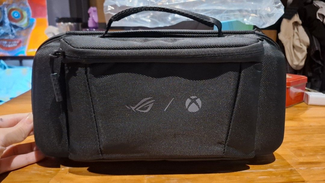 ASUS ROG Ally Xbox Premium Case (Category: Cases & Covers) located in Quezon City. Submitted by cyulaters (Listing ID 1469311834, Image 2). Description: - Official carrying case for ROG Ally handheld console - Sturdy outer shell provides excellent protection against bumps and drops - Soft molded interior fits the device snugly - Extra compartment included for chargers and small accessories - Convenient top handle for easy portability - Original b