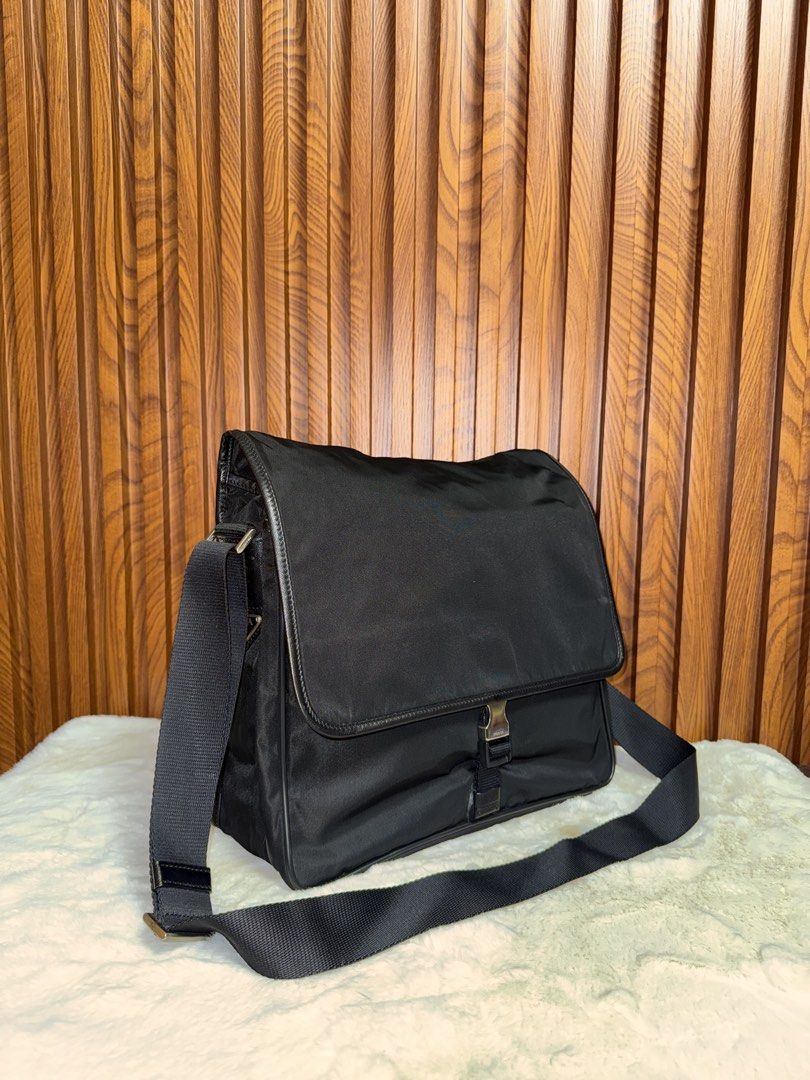 Authentic Prada Black Nylon Messenger Bag with Buckle (Category: Everything Else Others) located in Subic. Submitted by luxshoppe88 (Listing ID 1469279233, Image 2). Description: - Brand: Prada - Material: Classic black nylon - Closure: Front flap with branded metal buckle - Strap: Adjustable black shoulder strap - Pockets: Exterior back zip pocket and interior zip pocket - Interior: Signature Prada jacquard lining with metal logo plaque - Condit