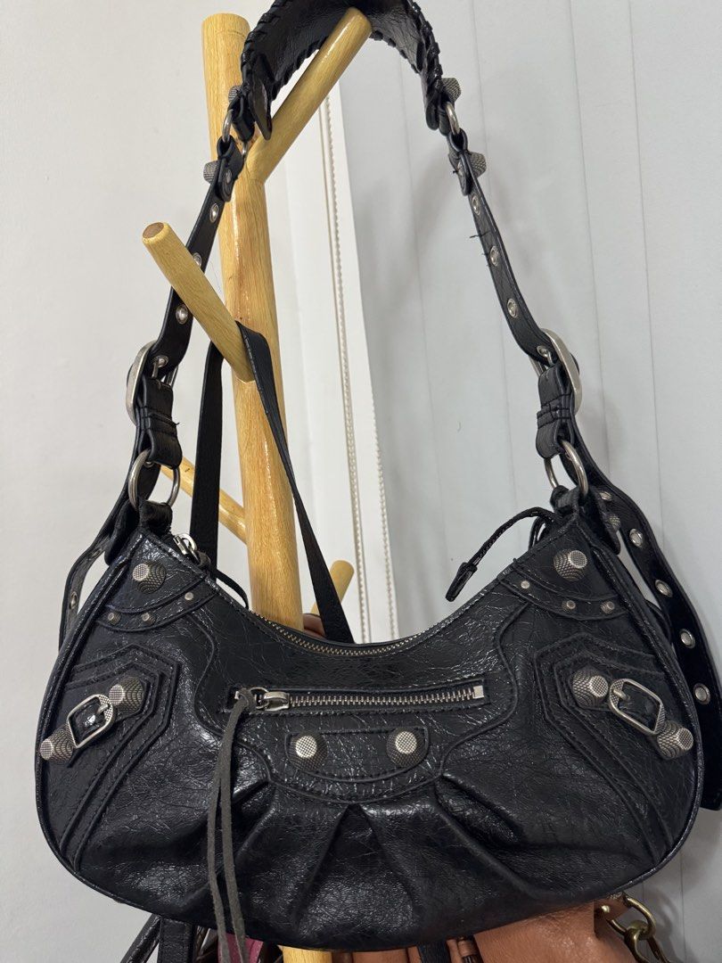 Balenciaga Le Cagole Shoulder Bag (Category: Luxury Bags & Wallets) located in Malolos. Submitted by urban_thrift_09 (Listing ID 1469222126, Image 2). Description: Balenciaga Le Cagole Shoulder Bag in black crinkled arena lambskin leather. -This distinctive maximalist design features a signature crescent silhouette, textured metal studs, buckles, braided strap details, and its accompanying detachable zipper pouch accessorized with long leather fr