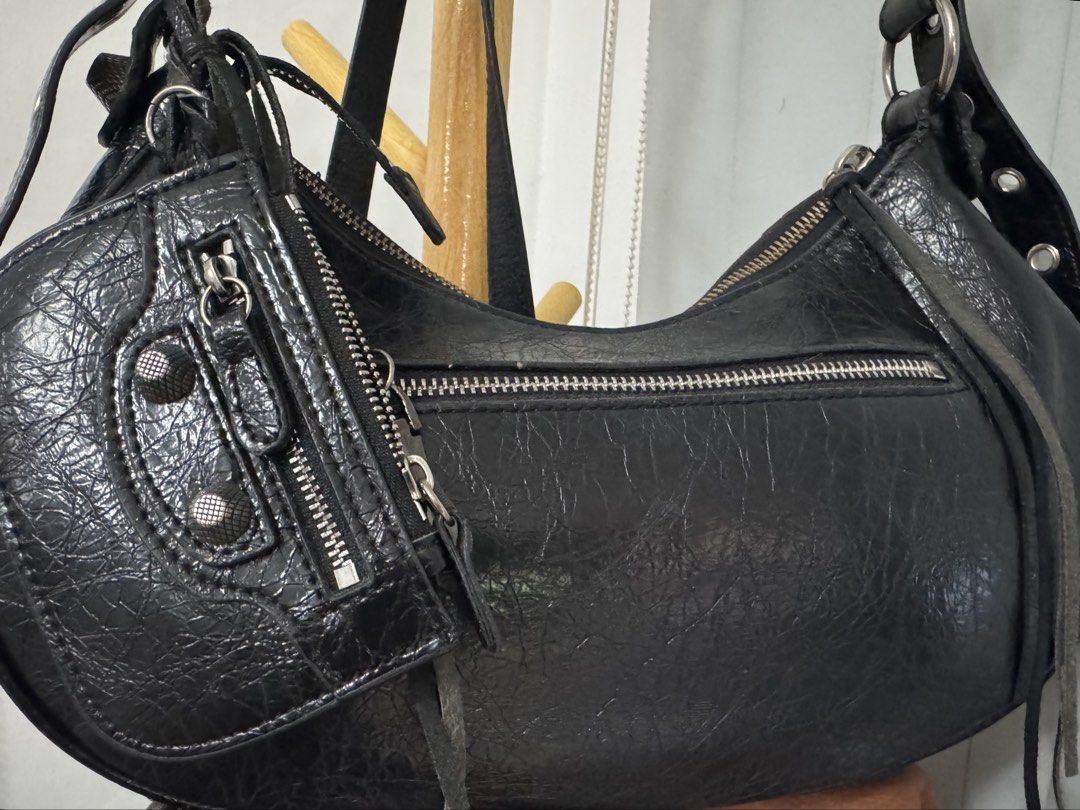 Balenciaga Le Cagole Shoulder Bag (Category: Luxury Bags & Wallets) located in Malolos. Submitted by urban_thrift_09 (Listing ID 1469222126, Image 3). Description: Balenciaga Le Cagole Shoulder Bag in black crinkled arena lambskin leather. -This distinctive maximalist design features a signature crescent silhouette, textured metal studs, buckles, braided strap details, and its accompanying detachable zipper pouch accessorized with long leather fr