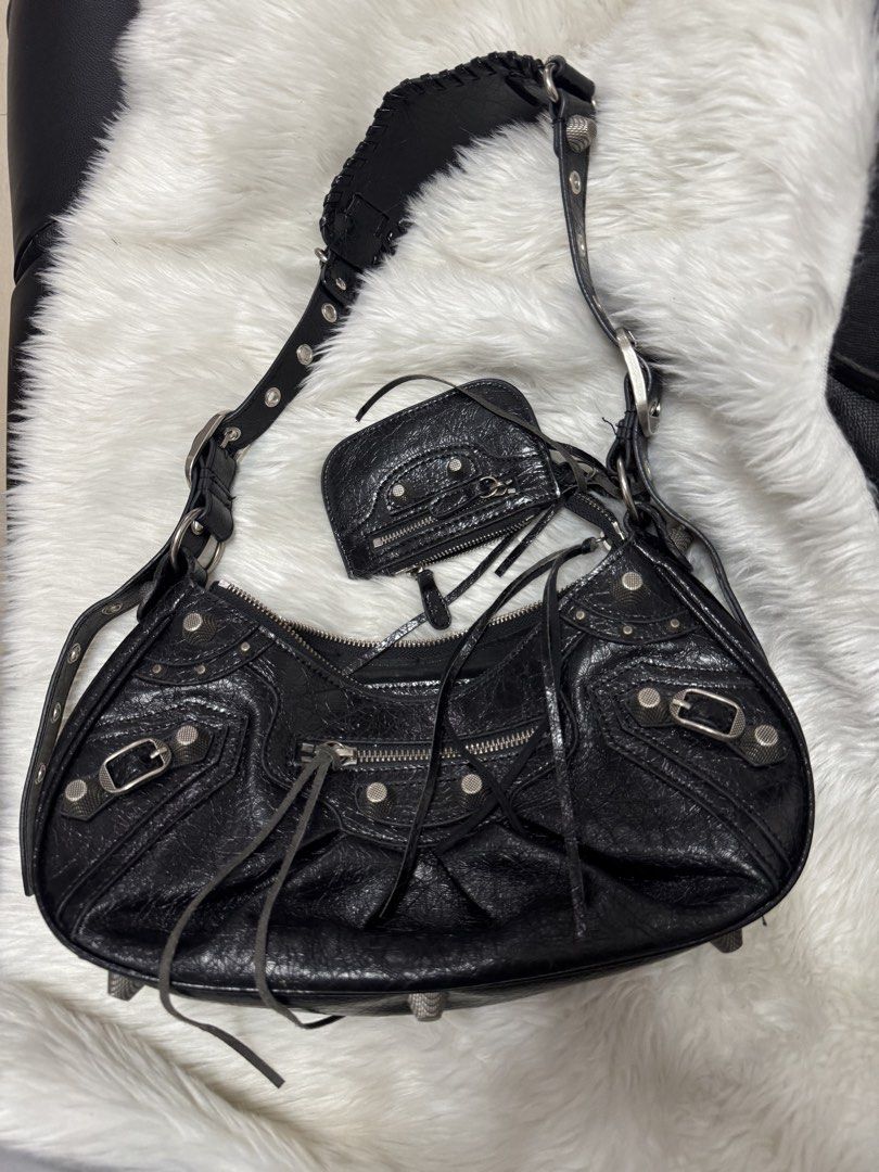 Balenciaga Le Cagole Shoulder Bag (Category: Luxury Bags & Wallets) located in Malolos. Submitted by urban_thrift_09 (Listing ID 1469222126, Image 1). Description: Balenciaga Le Cagole Shoulder Bag in black crinkled arena lambskin leather. -This distinctive maximalist design features a signature crescent silhouette, textured metal studs, buckles, braided strap details, and its accompanying detachable zipper pouch accessorized with long leather fr