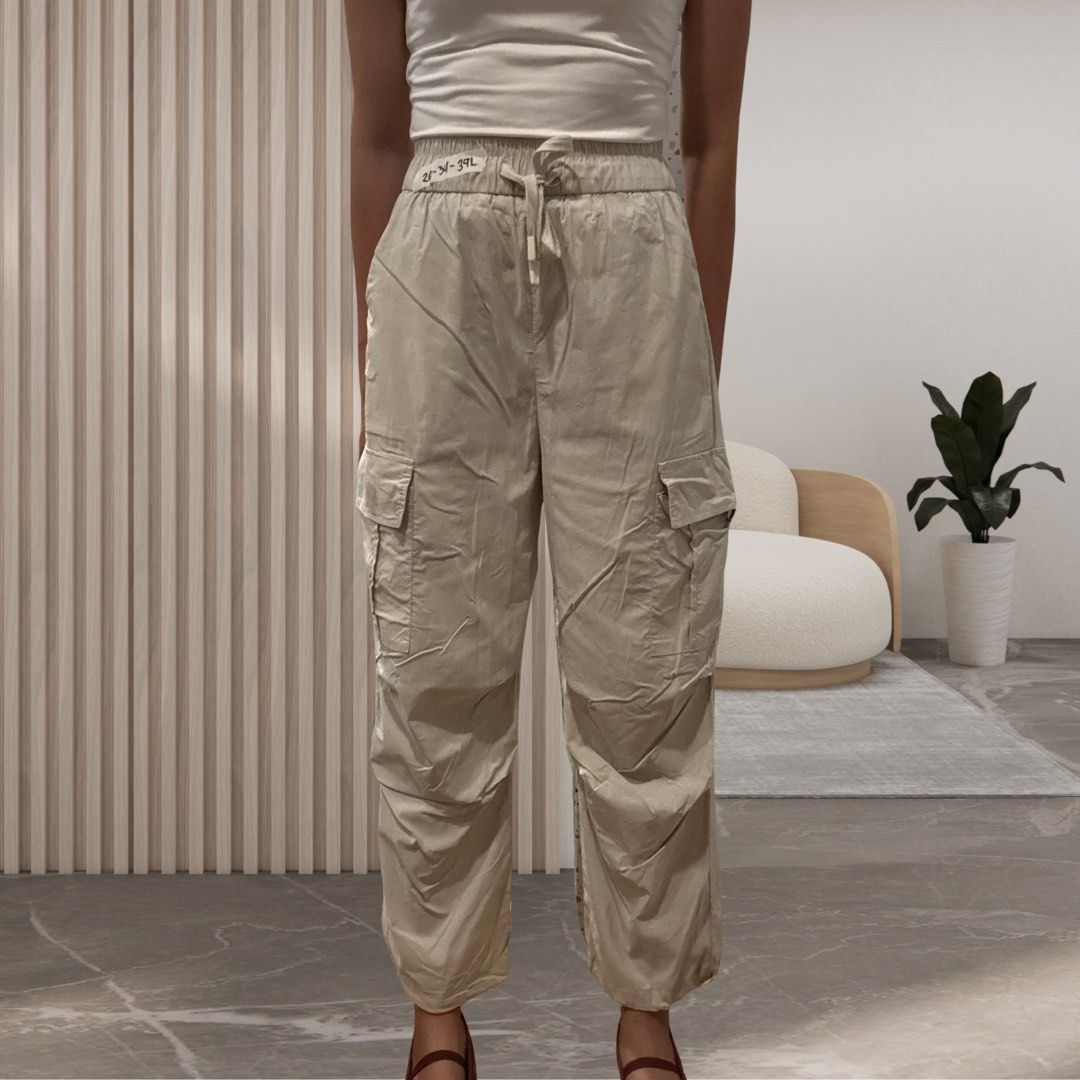 Beige high-waisted cargo pants with drawstring (Category: Jeans) located in Mandaluyong City. Submitted by shopwithjuu (Listing ID 1469377942, Image 1). Description: Size 26-34, 39in Length Trendy beige nylon cargo pants in a lightweight parachute material. Features a flattering high waist with an elastic drawstring, straight leg cut, and spacious utility pockets on both sides. Comfort meets street style!.