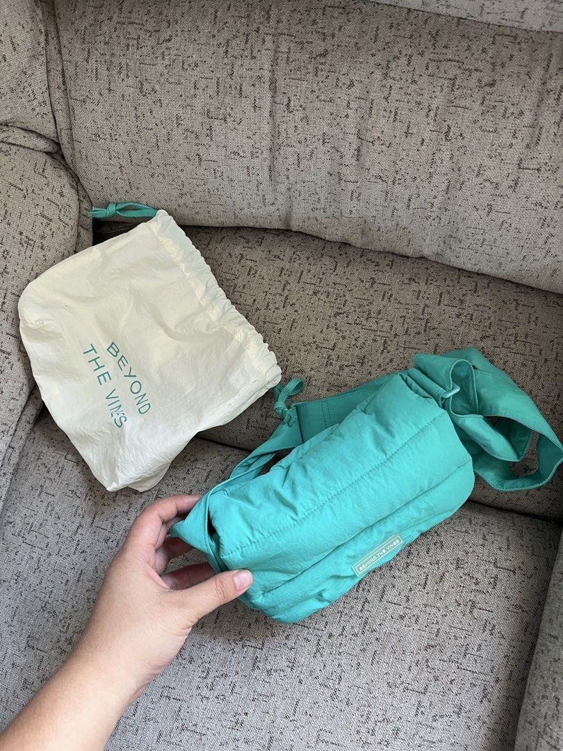 Beyond The Vines Dumpling Bag (Category: Cross-body Bags) located in Manila. Submitted by cokezer0__ (Listing ID 1469215370, Image 2). Description: - Brand: Beyond The Vines - Color: Teal - Material: Puffy nylon - Style: Crossbody bag with adjustable strap - Condition: Clean inside and out - Inclusion: Original branded dust bag with drawstring closure - Perfect for daily use.