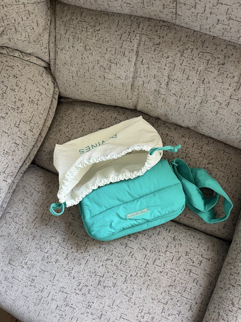 Beyond The Vines Dumpling Bag (Category: Cross-body Bags) located in Manila. Submitted by cokezer0__ (Listing ID 1469215370, Image 3). Description: - Brand: Beyond The Vines - Color: Teal - Material: Puffy nylon - Style: Crossbody bag with adjustable strap - Condition: Clean inside and out - Inclusion: Original branded dust bag with drawstring closure - Perfect for daily use.