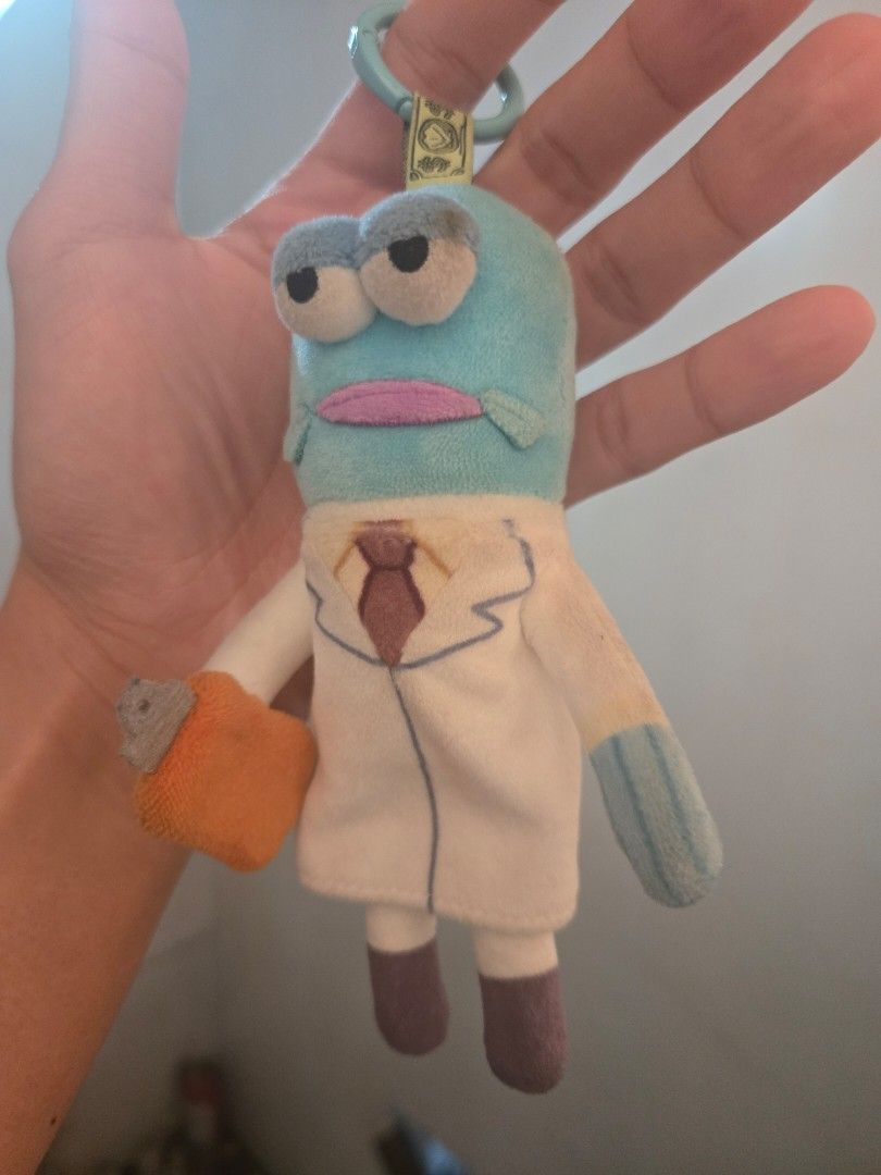 Bikini Bottom Buddies - Scientist Fish Plush Keychain (Category: Plushies & Soft Toys) located in Marikina City. Submitted by parcelpal.store (Listing ID 1469164662, Image 2). Description: - Official SpongeBob SquarePants Bikini Bottom Scientist Fish plush keychain - Design: Blue fish in a white lab coat holding a clipboard - Bonus: Includes a matching character art ID card - Size: Palm-sized, perfect for bags and keys - Hardware: Attached clasp 