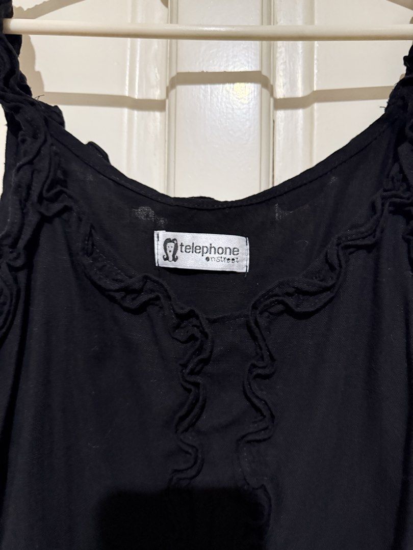 Black Cami Top (Category: Sleeveless) located in Marikina City. Submitted by louvy.r (Listing ID 1469378455, Image 2). Description: - Brand: Telephone Onstreet - Color: Black - Design: Cute ruffled straps, vertical ruffles on the front, and scoop neckline - Fabric: Lightweight and comfortable - Styling: Great basic piece for layering or wearing alone with jeans and skirts.