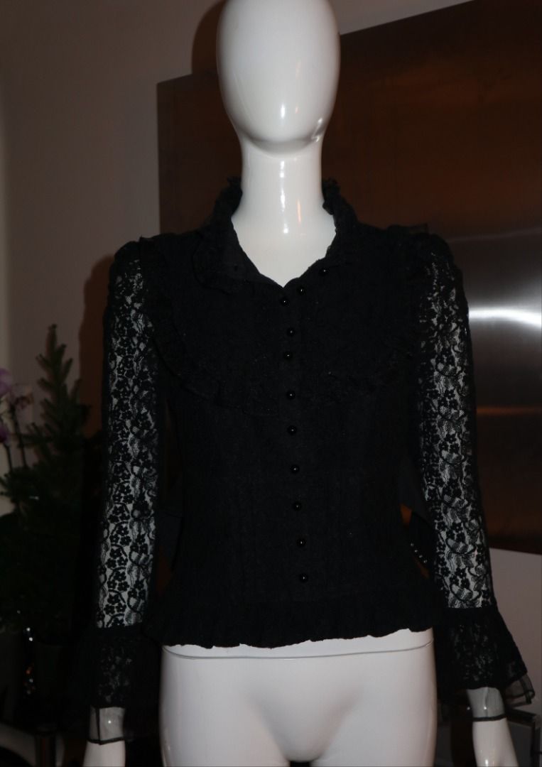 Black lace ruffled gothic blouse long sleeve button down (Category: Longsleeves) located in Paranaque City. Submitted by skulkch (Listing ID 1469362369, Image 2). Description: - Style: Dark romantic, gothic, vintage-inspired - Design: Button-down front with round black buttons, layered ruffles on chest and shoulders - Sleeves: Long bell sleeves with floral lace pattern - Collar: High ruffled collar - Fit: Fitted bodice with a flared hem - Conditi