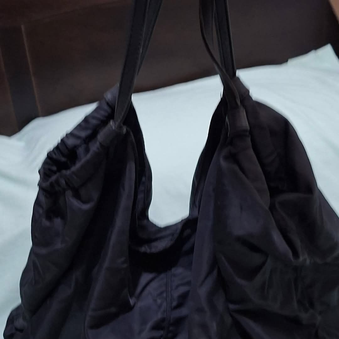 SALAD-Black Nylon Slouchy Shoulder Bag (Category: Shoulder Bags) located in Manila. Submitted by closetprincess (Listing ID 1469245168, Image 2). Description: - Color: Black - Material: Durable, lightweight nylon - Design: Soft, unstructured slouchy bag with gathered elastic openings and center vertical seam - Straps: Dual thin carrying straps - Compartment: Deep main compartment, perfect for daily essentials - Feature: Folds completely flat when