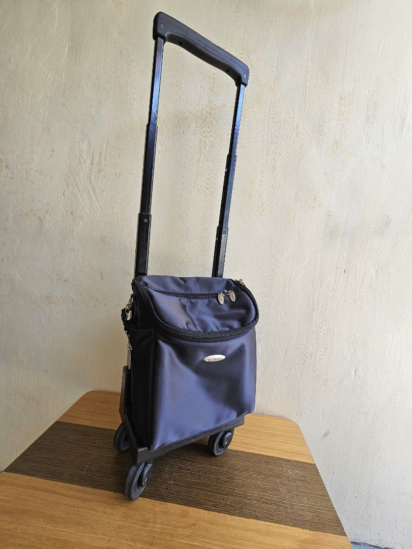 Black Rolling Trolley Bag with Retractable Handle (Category: Luggage) located in Meycauayan. Submitted by amazinggrace_143 (Listing ID 1469291450, Image 2). Description: - Color: Sleek black - Material: Durable nylon - Mobility: Sturdy retractable handle and smooth rolling wheels - Organization: Multiple inner and outer compartments plus side pockets for water bottles - Size: Compact, fits overhead storage - Best for: Travel and daily commutes.