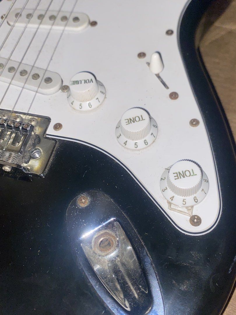 Black Stratocaster Style Electric Guitar (Category: Musical Instruments) located in Manila. Submitted by 4everch1ro (Listing ID 1469344745, Image 2). Description: - Stratocaster-style electric guitar in classic black with a white pickguard - visible rust on screws, pickup poles, and bridge - Rushed sale, PM for inquiries! INCLUSIONS : Guitar Bag Amp cord Loc : Malate, Manila RFS: need funds for ipad :C.