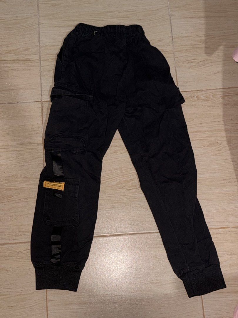 Black Techwear Cargo Joggers with Straps and Pockets (Category: Joggers) located in Solano. Submitted by blkcat1221 (Listing ID 1469257113, Image 2). Description: - Color: Black - Style: Streetwear cargo joggers - Fit: Super comfortable for everyday wear - Waistband: Elastic with adjustable drawstring closure - Cuffs: Ribbed ankle cuffs - Pockets: Multiple utility pockets down the sides - Details: Features decorative straps and a small yellow bra