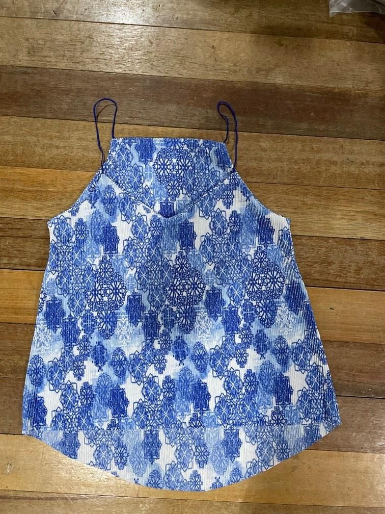 Blue and White Patterned Spaghetti Strap Tank Top (Category: Sleeveless) located in Mandaue City. Submitted by isabelle915 (Listing ID 1469236328, Image 2). Description: - Blue and white patterned design - Lightweight pleated fabric - Thin spaghetti straps with square neckline - High-low hemline (longer in the back) - Condition: Clean and ready to wear - Perfect for pairing with jeans or shorts in warm weather.
