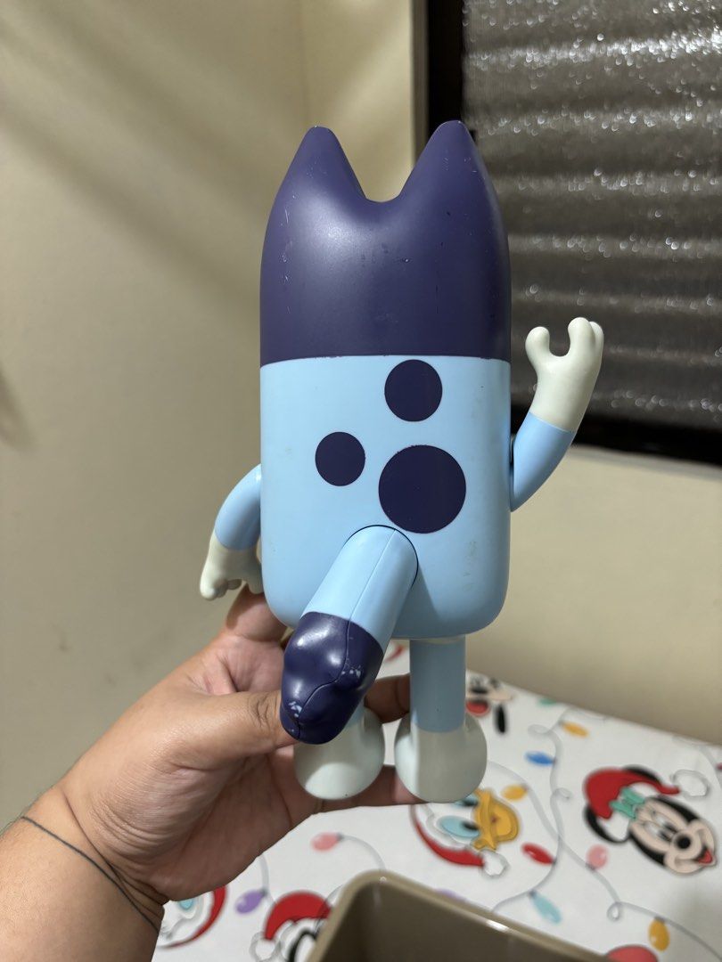 Bluey Action Figure Toy Poseable Character (Category: Figurines & Statues) located in Makati City. Submitted by jhonnared (Listing ID 1469174333, Image 2). Description: - Official Bluey character toy with classic smiling face - Movable arms and legs (can sit or stand) - Stands upright on its own without falling over - Ideal for playtime or shelf display - Condition: Has minor paint scuff marks from regular play.