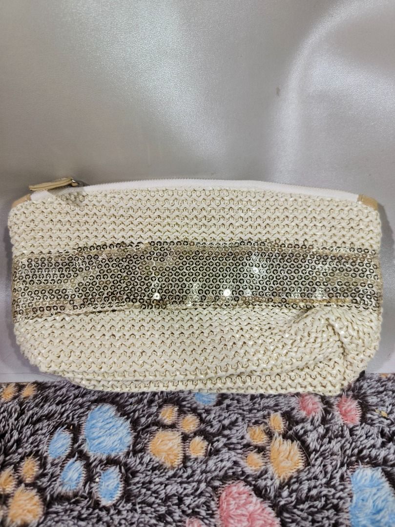 Boho Straw Makeup Pouch with Gold Sequins (Champagne/Cream) (Category: Purses & Pouches) located in San Leonardo. Submitted by burgossanleonardo.12345 (Listing ID 1469273361, Image 1). Description: • Design: Cream/beige woven raffia-style straw knit body featuring a thick horizontal stripe of metallic gold sequins across the front and back. • Interior: Fully lined with a slick, wipeable champagne gold satin fabric. Features a main pocket and a sm