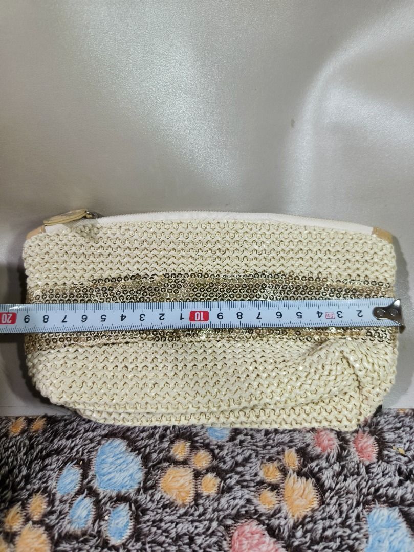 Boho Straw Makeup Pouch with Gold Sequins (Champagne/Cream) (Category: Purses & Pouches) located in San Leonardo. Submitted by burgossanleonardo.12345 (Listing ID 1469273361, Image 2). Description: • Design: Cream/beige woven raffia-style straw knit body featuring a thick horizontal stripe of metallic gold sequins across the front and back. • Interior: Fully lined with a slick, wipeable champagne gold satin fabric. Features a main pocket and a sm
