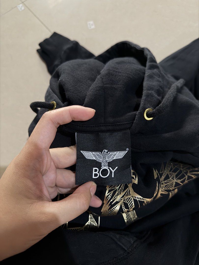 BOY LONDON HOODIE JACKET (Category: Coats, Jackets and Outerwear) located in Manila. Submitted by zna_onlineshop (Listing ID 1469235633, Image 2). Description: - 100% Authentic Boy London hoodie in classic black - Size: Small (Measures 21.5" pit-to-pit x 26" length) - Striking gold geometric eagle graphic and logo lettering - Practical kangaroo pocket and drawstring hood with gold-tone metal eyelets - Made of 100% comfortable cotton - Guaranteed 