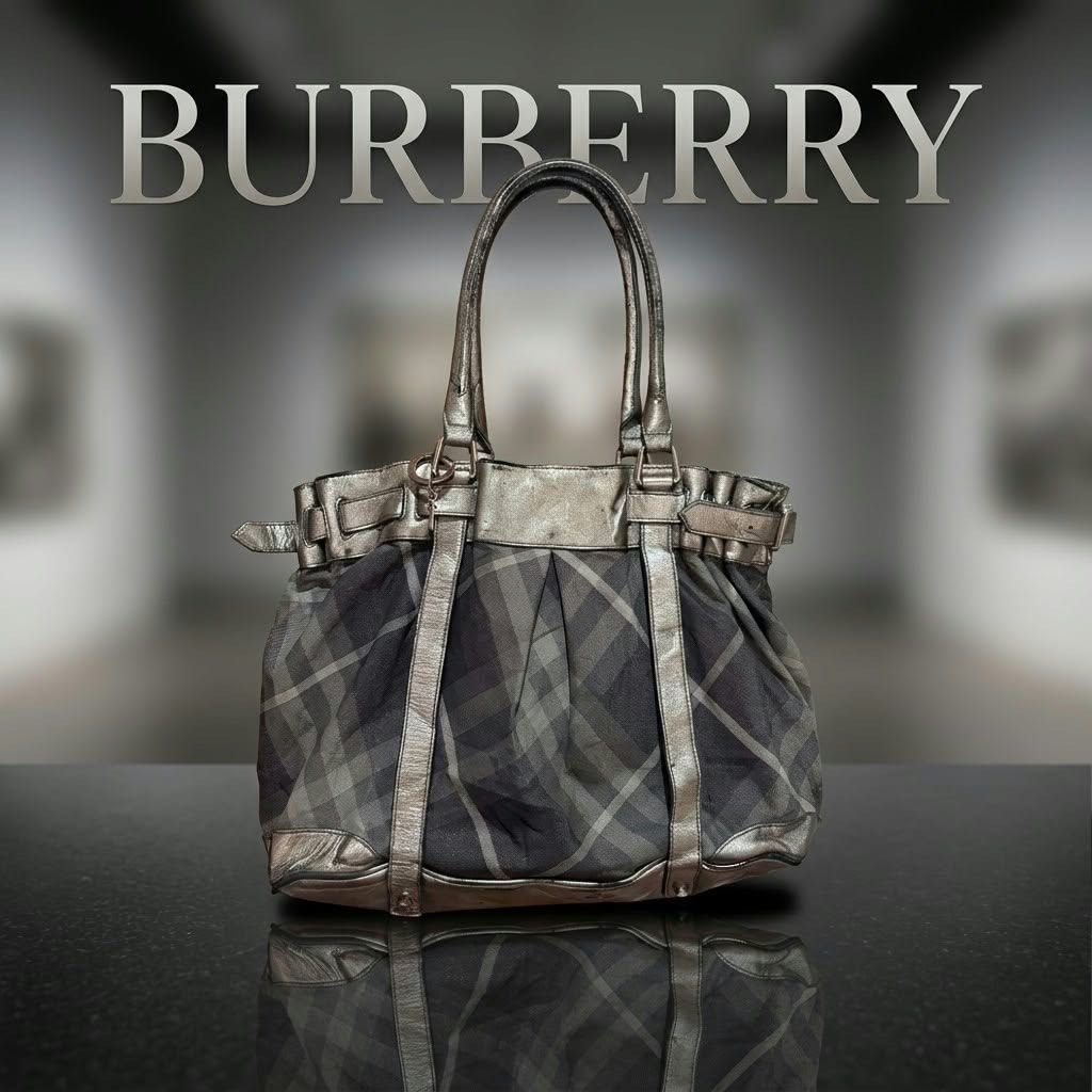 Burberry Plaid Metallic Tote Bag (Category: Luxury Bags & Wallets) located in Carmen. Submitted by rr_thrifts (Listing ID 1469173929, Image 1). Description: - Authentic Burberry tote bag in iconic classic plaid fabric - Stylish metallic leather trim with matching double shoulder straps - Chic side buckle details and branded metal ring charm included - Spacious interior perfect for daily essentials - Flaw note: Please expect some wear and dark scu