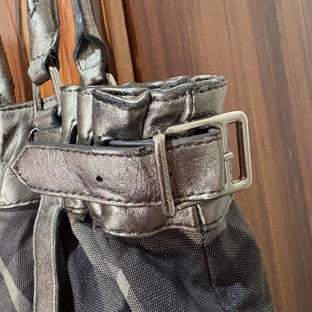 Burberry Plaid Metallic Tote Bag (Category: Luxury Bags & Wallets) located in Carmen. Submitted by rr_thrifts (Listing ID 1469173929, Image 3). Description: - Authentic Burberry tote bag in iconic classic plaid fabric - Stylish metallic leather trim with matching double shoulder straps - Chic side buckle details and branded metal ring charm included - Spacious interior perfect for daily essentials - Flaw note: Please expect some wear and dark scu