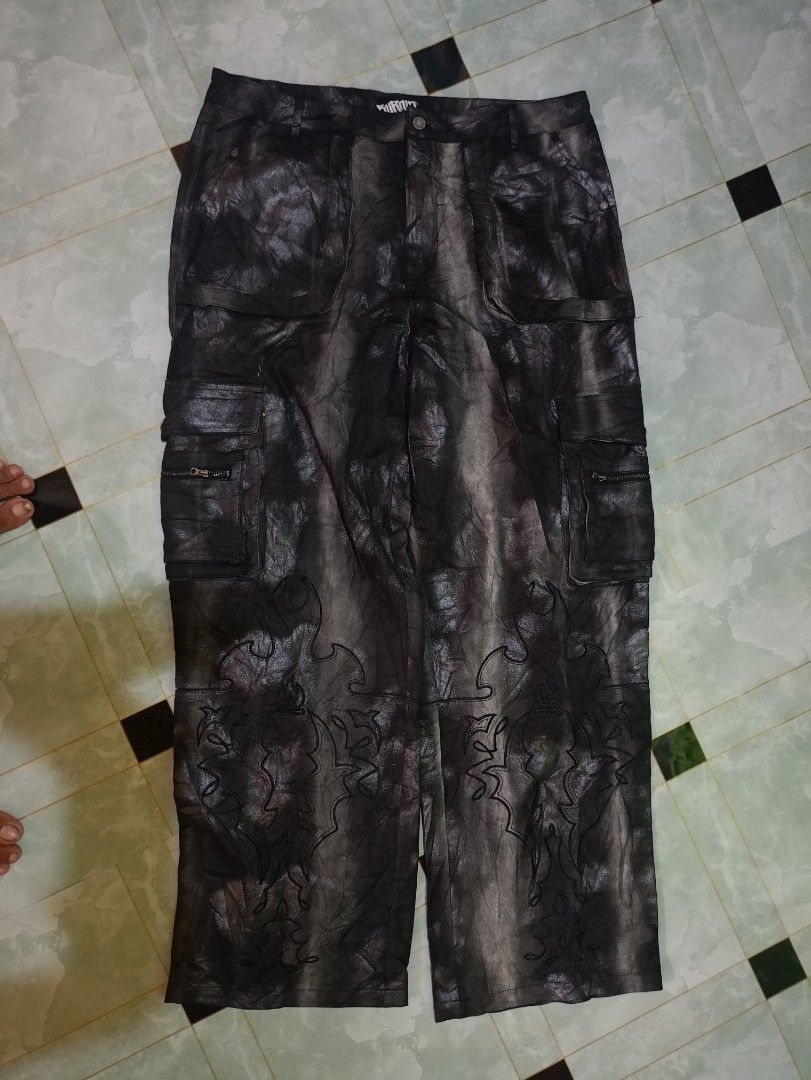 Burfict Black Coated Cargo Pants with Embroidery (Category: Jeans) located in General Mariano Alvarez. Submitted by markaj1699 (Listing ID 1469175817, Image 1). Description: - Brand/Model: Burnin Black Coated Denim Cargo Pants - Wash/Finish: Distressed metallic wash effect for a unique edge - Pockets: Multiple utility pockets equipped with zip details - Detailing: Intricate gothic embroidery on the lower legs - Hardware: Branded metal buttons and
