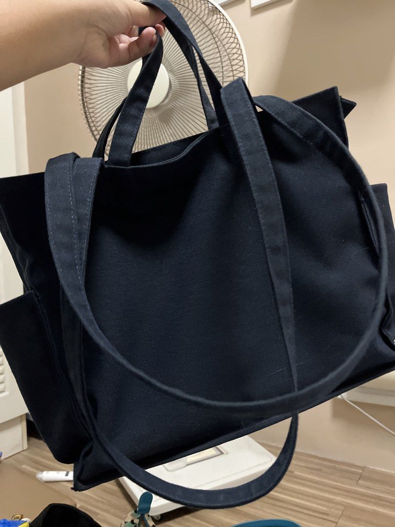byBTG Boxy Tote (Category: Tote Bags) located in Cardona. Submitted by minyoonji (Listing ID 1469263133, Image 2). Description: - Brand: byETG - Material: Durable black canvas - Design: Structured shape with sturdy double straps and top zipper closure - Exterior: Deep front pockets for quick access - Interior: Multiple compartments and practical slip pockets for easy organization - Condition: Minimal wear, clean inner lining.