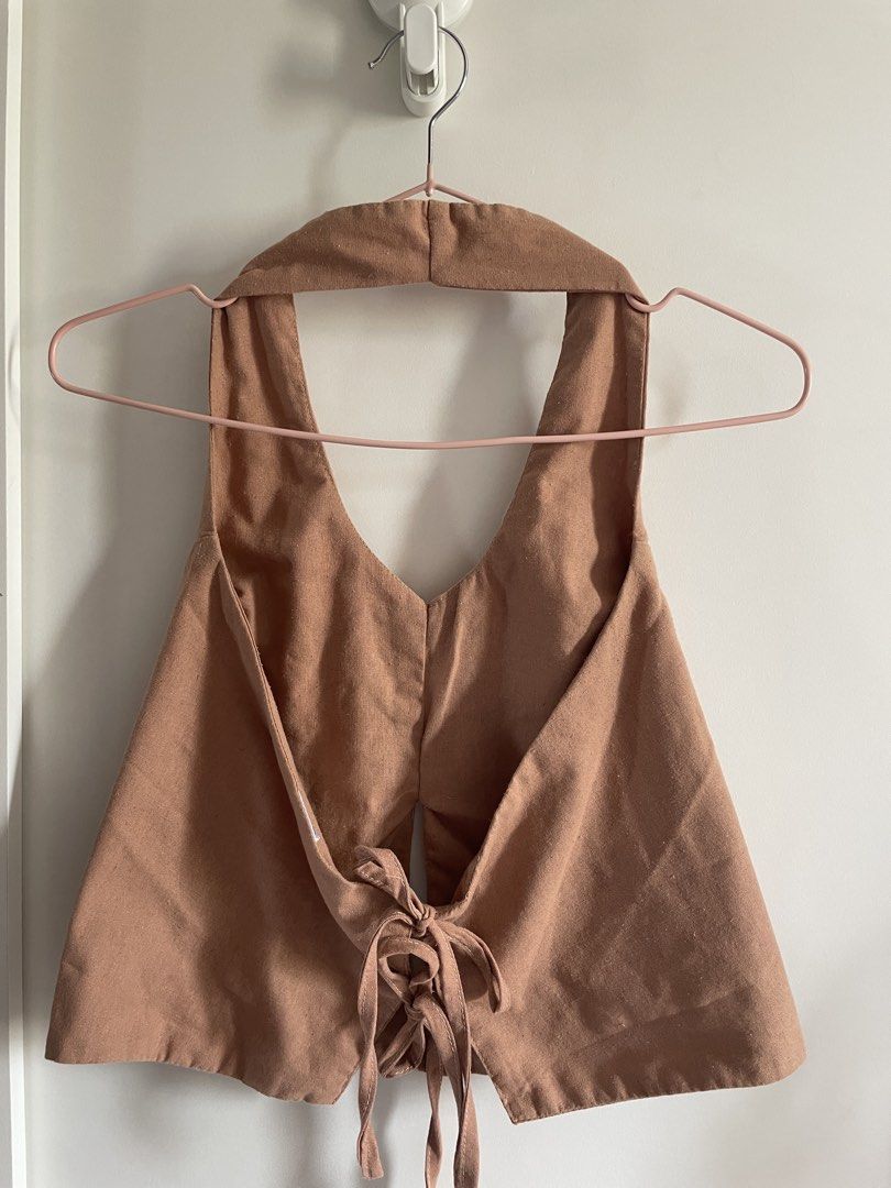 Calista Apparel Brown Halter Top Size M (Category: Sleeveless) located in Agdangan. Submitted by happyphoenix.d92869 (Listing ID 1469210643, Image 2). Description: - Brand: Calista Apparel - Size: M - Color: Brown - Style: Halter top with open back and tie-back ribbon detail at the hem - Material: Textured fabric with structured front panels.