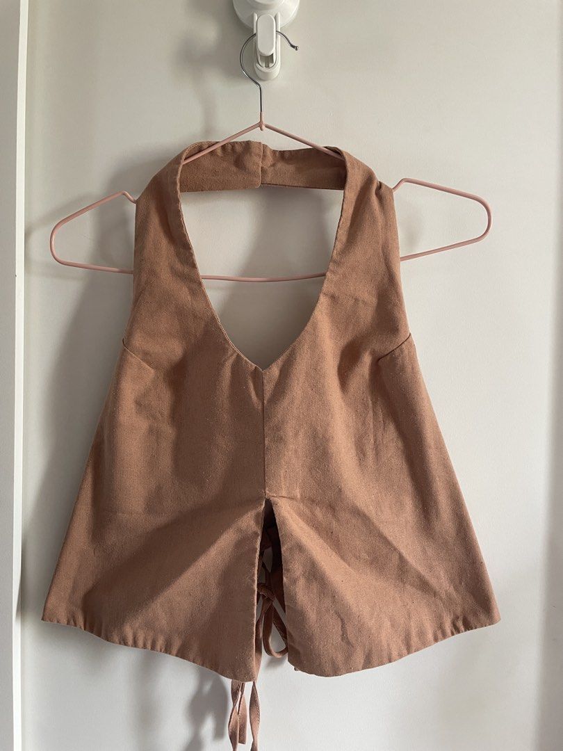 Calista Apparel Brown Halter Top Size M (Category: Sleeveless) located in Agdangan. Submitted by happyphoenix.d92869 (Listing ID 1469210643, Image 1). Description: - Brand: Calista Apparel - Size: M - Color: Brown - Style: Halter top with open back and tie-back ribbon detail at the hem - Material: Textured fabric with structured front panels.