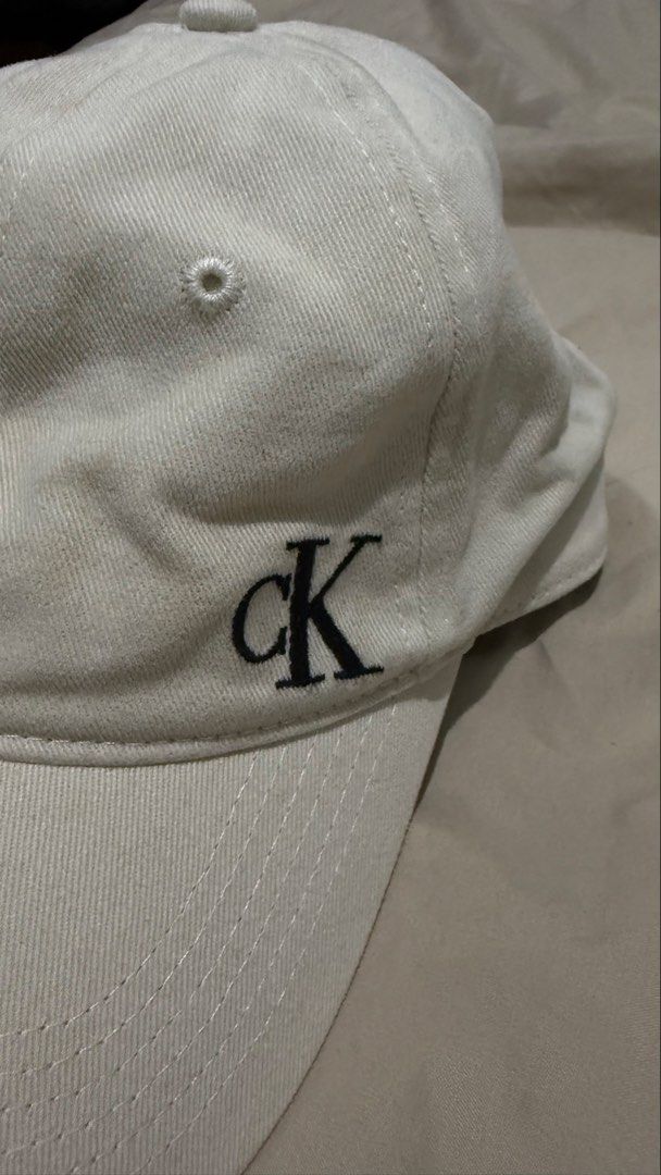 Calvin Klein Baseball Cap (Category: Caps & Hats) located in Makati City. Submitted by clutterfreejia (Listing ID 1469224879, Image 3). Description: Store bought at ₱1600 Color: cream / light beige Needs cleaning / wash No flaws other than the stains due to storage Rfs: decluttering.