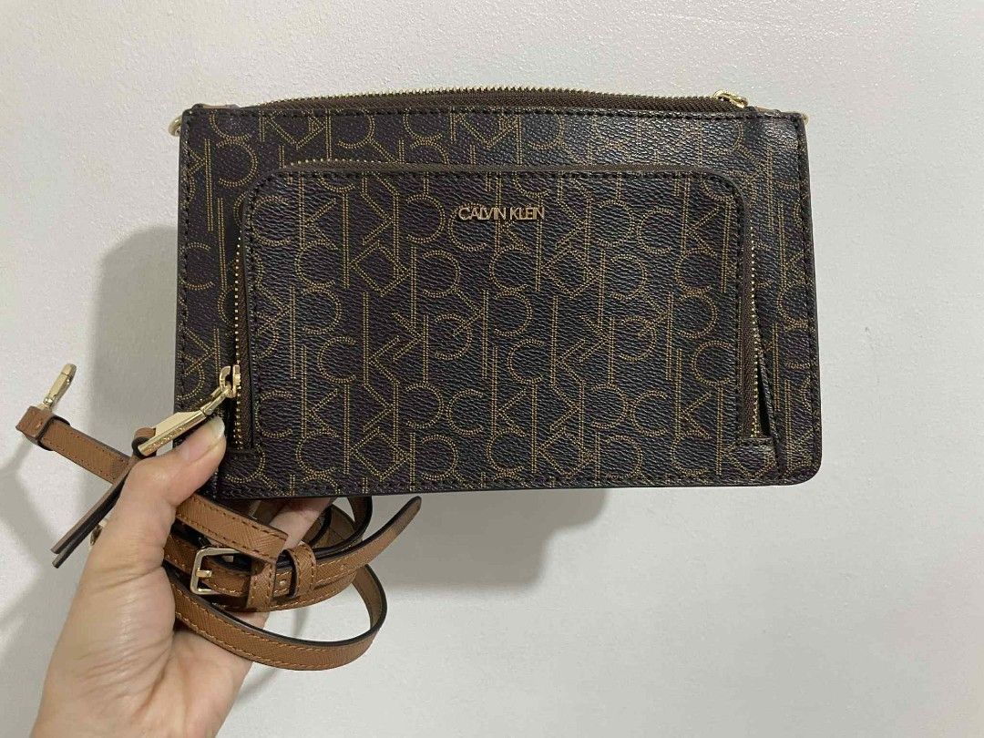 Calvin Klein Monogram Brown Crossbody Bag (Category: Cross-body Bags) located in San Pedro. Submitted by alessandrachic (Listing ID 1469313263, Image 1). Description: - Brand: Calvin Klein - Color: Dark brown with all-over monogram pattern - Hardware: Gold-tone - Strap: Matching brown, adjustable - Pockets: Front zipper pocket with CK lettering, interior slip pocket - Interior: Signature CK logo fabric lining - Condition: Clean, zippers work smoo