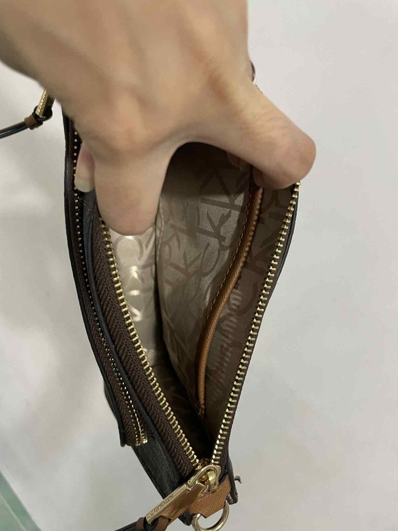 Calvin Klein Monogram Brown Crossbody Bag (Category: Cross-body Bags) located in San Pedro. Submitted by alessandrachic (Listing ID 1469313263, Image 2). Description: - Brand: Calvin Klein - Color: Dark brown with all-over monogram pattern - Hardware: Gold-tone - Strap: Matching brown, adjustable - Pockets: Front zipper pocket with CK lettering, interior slip pocket - Interior: Signature CK logo fabric lining - Condition: Clean, zippers work smoo