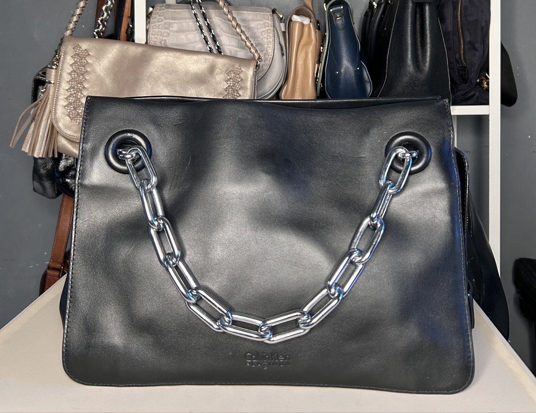 Calvin Klein Platinum Black Leather Shoulder Bag (Category: Shoulder Bags) located in Manila. Submitted by ekailacerna (Listing ID 1469314655, Image 1). Description: - Brand: Calvin Klein Platinum - Color: Black leather exterior with pink suede-like interior lining - Hardware: Silver-toned hardware throughout - Handles: Includes a trendy chunky silver chain handle plus a detachable long black shoulder strap - Compartments: Features a convenient c